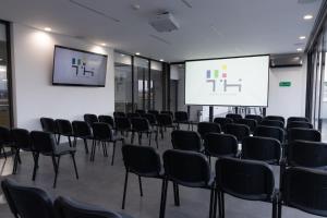 a conference room with chairs and a projection screen at TH HOTEL & VIVIENDA in Tepatitlán de Morelos +174 photos