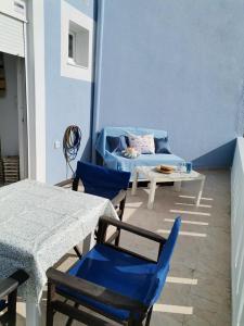 a patio with a couch and a table and chairs at Seafront Aegean Νest in Karpathos Town