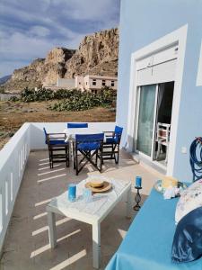 un patio con tavolo e sedie sul balcone. di Seafront Aegean Νest a Karpathos