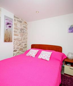 a bedroom with a pink bed with two pillows at Villa Capo in Split