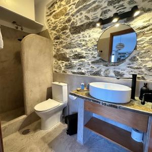 a bathroom with a sink and a toilet and a mirror at Peristerionas Estate in Karistos