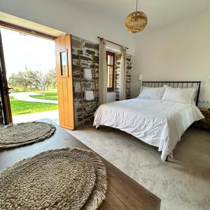 a bedroom with a large bed and a large window at Peristerionas Estate in Karistos