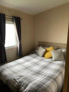 a bedroom with a bed with two pillows and a window at 9 shearwater Tattershall Lakes Country Park in Tattershall