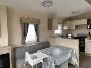 una pequeña cocina con mesa en una caravana en 9 shearwater Tattershall Lakes Country Park, en Tattershall