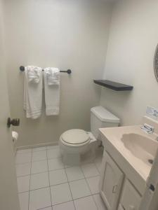 La salle de bains blanche est pourvue de toilettes et d'un lavabo. dans l'établissement Aloha Condominium On the Intracoastal-Walk to the Beach, à Pompano Beach