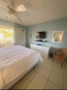 1 dormitorio con 1 cama, TV y silla en Aloha Condominium On the Intracoastal-Walk to the Beach, en Pompano Beach