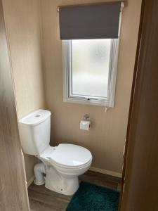 een kleine badkamer met een toilet en een raam bij 9 shearwater Tattershall Lakes Country Park in Tattershall