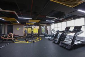 - une salle de sport avec des tapis de course et des machines dans l'établissement Dubai Downtown French Chic Apartment, à Dubaï