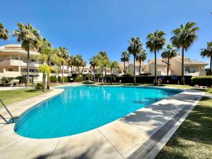 a swimming pool with palm trees and houses at El Arenal Townhouse By The Beach With Swimming Pool - EaW Homes in Marbella