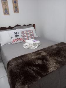 a bed with a black fur blanket and pillows at Casa Vista para Serra in Tiradentes