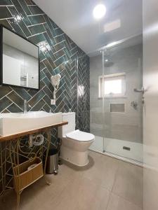 een badkamer met een toilet, een wastafel en een douche bij Baia do Mundo in Setúbal