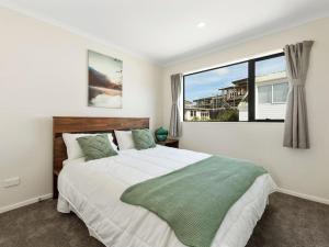 a bedroom with a large bed with a large window at Home Away From Home! in Auckland