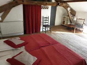een slaapkamer met een rood bed en een rood gordijn bij Au Ruisseau de Rose in Saint-Jean-du-Gard