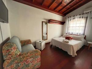 a living room with a bed and a couch at Casarão Paraty in Paraty