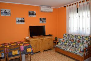 sala de estar con sofá y TV de pantalla plana en Casa Rural Javier, en Valmuel