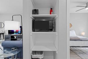 a living room with a bed and a microwave at Bright & Comfy 1 Bedroom Flat - Hollywood Suites in Mount Clemens