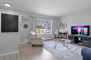 a living room with a tv and a couch and a table at Bright & Comfy 1 Bedroom Flat - Hollywood Suites in Mount Clemens