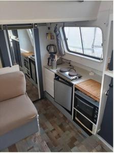 a small kitchen in an rv with a stove at Bateau pénichette atypique in Nantes