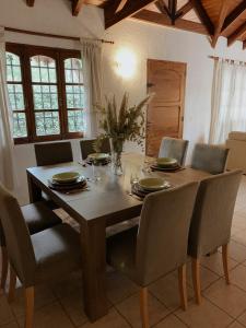 een eettafel met stoelen en een houten tafel en een stoeltje bij Casa Amelia in Ciudad Lujan de Cuyo