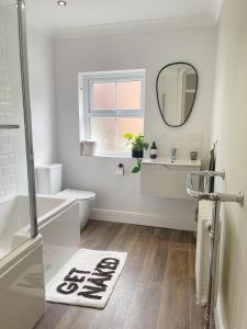 bagno con lavandino e specchio. di Family Friendly House in Norwich with Parking a Norwich