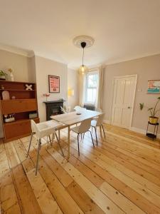 a living room with a table and chairs and a fireplace at Family Friendly House in Norwich with Parking in Norwich