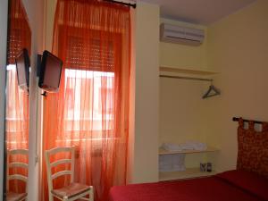 una camera da letto con finestra e tenda arancione di A Casa di Carla a Terni