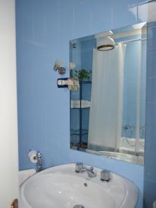 a blue bathroom with a sink and a mirror at A Casa di Carla in Terni