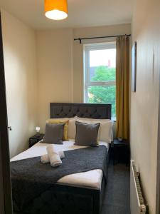 a bedroom with a large bed with a window at Balfour - Beautiful refurbished spacious 3 bedroom Gateshead flat in Gateshead