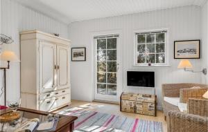 a living room with a large white cabinet and windows at Nice Home In Hirtshals With Wifi in Hirtshals
