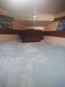 un letto con un cuscino marrone sopra di super Voilier Eve a Gruissan