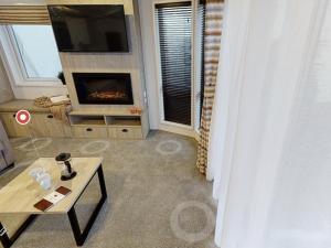 a living room with a tv and a fireplace at Sherwood Lodge in Cheddar