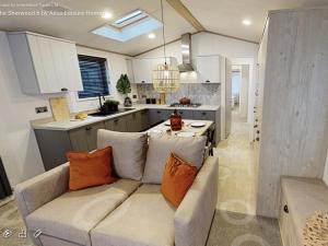 a living room with a couch and a kitchen at Sherwood Lodge in Cheddar