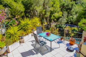 un patio con mesa, sillas y plantas en Monica II - holiday home with private swimming pool in Benissa, en Benissa