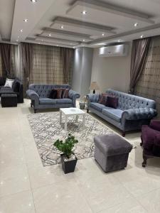 Cozy and Modern Apartment for Rent in Mohandessin في القاهرة: غرفة معيشة كبيرة مع كنب وطاولة