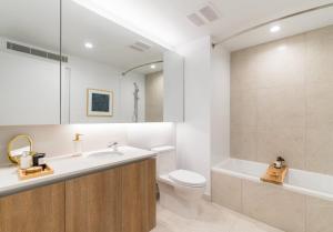 a bathroom with a sink and a toilet and a tub at Sky Rise Apartments in Los Angeles