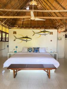 1 dormitorio con 1 cama con 3 peces en la pared en Isla Mulata, Islas del Rosario en Isla Grande