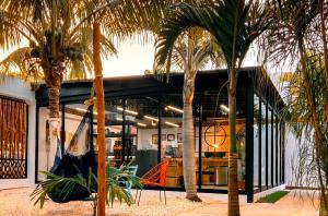 a house with palm trees and a hammock in front of it at Mezcal Hostel in Cancún