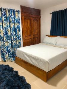 een slaapkamer met een bed met blauwe en witte gordijnen bij Ocean View Apart. In Down town in San Felipe de Puerto Plata