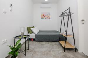 ein Wohnzimmer mit einem Bett und einem Tisch in der Unterkunft Lovely apartment M&K in peaceful area - Zadar in Zadar