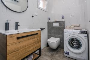 ein Badezimmer mit einem Waschbecken und einer Waschmaschine in der Unterkunft Lovely apartment M&K in peaceful area - Zadar in Zadar