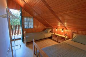 1 dormitorio con 2 camas en una habitación de madera en Holiday House Klara en Otočac