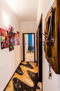 a hallway with a tile floor and a door with paintings at Naxos Sea Holiday Apartments in Giardini Naxos