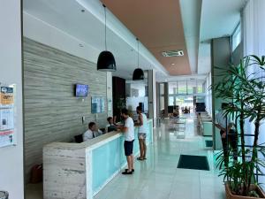 a group of people standing at a counter in a restaurant at Verano Stay Flat Trab E Relax in Rio de Janeiro