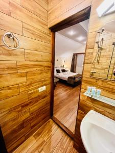 baño con espejo, lavabo y cama en Hotel British House, en Tiflis