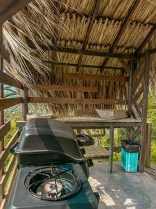 een grill op een patio in een houten gebouw bij All Natural Glamping in Copacabana