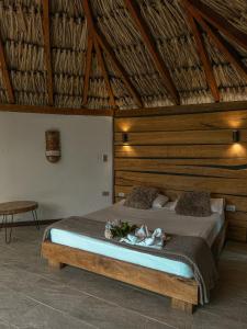 sypialnia z dużym łóżkiem z drewnianym zagłówkiem w obiekcie All Natural Glamping w mieście Copacabana