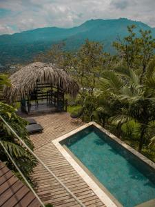 una piscina en una terraza de madera con una cabaña en All Natural Glamping en Copacabana