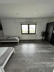 Habitación vacía con 2 camas y ventana en Messewohnung/Ferienwohnung, en Colonia