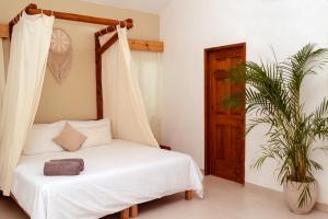 a bedroom with a bed with a canopy at Mezcal Hostel in Cancún