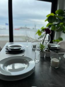 einen Tisch mit Tellern, Gläsern und Blumen darauf in der Unterkunft Messewohnung/Ferienwohnung in Köln